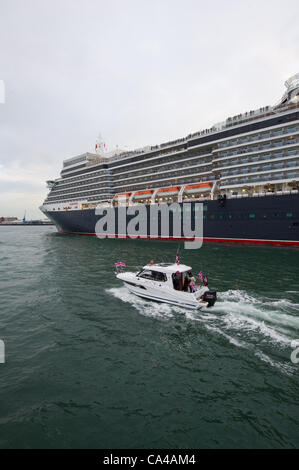 Southampton, UK. The three Cunard cruise ships Queen Elizabeth, Queen Victoria and Queen Mary 2 arrive at Southampton Docks at dawn for the diamond jubilee celebrations on June the 5th 2012. Queen Elizabeth with small pleasure craft following. Credit:  Stefan Venter / Alamy Live News Stock Photo