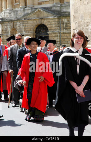 Oxford, UK. Wednesday June 20th 2012. Daw Aung San Suu Kyi (in red) walks in the Oxford University Encaenia procession. Aung San Suu Kyi is Chairman of the Burmese National League for Democracy and member of the Burmese parliament  She is awarded the Honorary Degree of Doctor of Civil Law by Oxford University from which she graduated in 1969 in recognition of her fight for democracy in Burma. Stock Photo