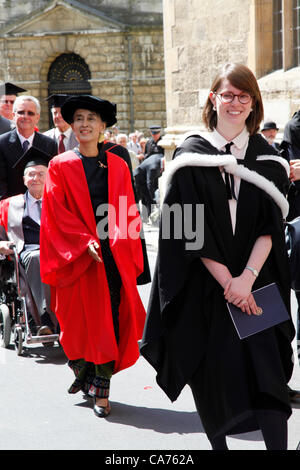 Oxford, UK. Wednesday June 20th 2012. Daw Aung San Suu Kyi (in red) walks in the Oxford University Encaenia procession. Aung San Suu Kyi is Chairman of the Burmese National League for Democracy and member of the Burmese parliament  She is awarded the Honorary Degree of Doctor of Civil Law by Oxford University from which she graduated in 1969 in recognition of her fight for democracy in Burma. Stock Photo