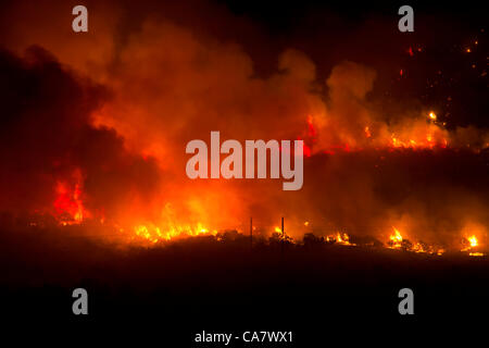Forest fire rages with intense flames and smoke during night in central Utah. Wood Hollow blaze on edge of rural community of Fountain Green. Fire spreads across many miles if dry drought  stricken grass, shrubs and trees. Several structures and cabins have been destroyed. Area has many cattle, shee