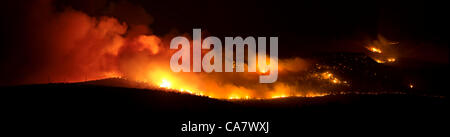 Forest fire rages with intense flames and smoke during night in central Utah. Wood Hollow blaze on edge of rural community of Fountain Green. Fire spreads across many miles if dry drought  stricken grass, shrubs and trees. Several structures and cabins have been destroyed. Area has many cattle, shee Stock Photo
