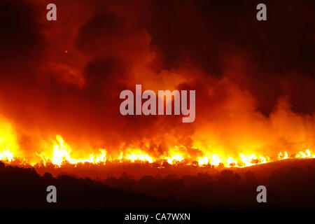 Forest fire rages with intense flames and smoke during night in central Utah. Wood Hollow blaze on edge of rural community of Fountain Green. Fire spreads across many miles if dry drought  stricken grass, shrubs and trees. Several structures and cabins have been destroyed. Area has many cattle, shee Stock Photo