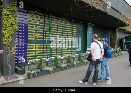 25.06.2012. The Wimbledon Tennis Championships 2012 held at The All England Lawn Tennis and Croquet Club, London, England, UK.  Around the grounds - General view. Spectators studying the schedule of play. Stock Photo