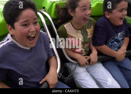 (SignOn: 06/16/2003; Published 06/16/2003, A-1): Carlos Guaderrama, 11, Brenda Hernandez, 10, and Chirstian Ahumada, 7, scream as they ride the Crazy Mouse roller coaster at the 2003 San Diego County Fair on Sunday. UT photo by Eduardo Contreras Stock Photo