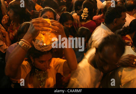 KUALA LUMPUR, MALAYSIA FEBRUARY 4, 2004  Woman holds a pot of milk as offering on her head as she partakes in pilgramidge to the temple at Batu caves on the eve of Thaipusam festival, February 4. 2004. More than 1 million people, in two days of almost unbroken procession, climb steep steps to the en Stock Photo