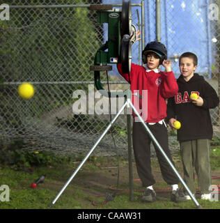 (l to r) Damon Palacio, 10, and Zachary Larson, 9, of the Blue Bombers launch a few 50mph fastballs out of the pitching machine at Left Gomez Field on Thursday February 5, 2004 in Rodeo, Calif.  The two have been practicing their hitting for two weeks and plan to practice up to the opening of the se Stock Photo
