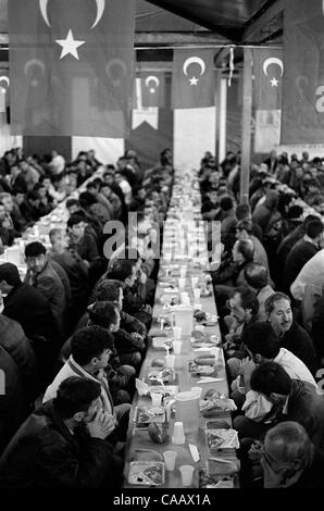 A free dinner for thousands is served in Taksim Square, Istanbul, on the first night of Ramadan, the Moslem month of fasting. Moslems do not eat from sunrise to sunset during the month of Ramadan. Stock Photo