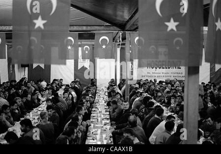 A free dinner for thousands is served in Taksim Square, Istanbul, on the first night of Ramadan, the Moslem month of fasting. Moslems do not eat from sunrise to sunset during the month of Ramadan. Stock Photo