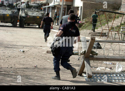 Mar 22, 2004; Kosovo, SERBIA; KFOR peacekeeper UNMIK police search a building for an Albanian sniper, who shot and injured several Serbian civilians in Kosovska Mitrovica. A guarded bridge is all that that divides this troubled city into North (controlled by Serbs) and South (controlled by Albanians Stock Photo