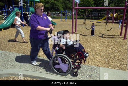 Liz Lamach wheels her disabled son Matteo, 4, into Hillcrest Park in Concord, Calif., on April 7, 2004.   Lamach is spearheading an effort to create an 'all-abilities' park where disabled and fully-abled children can play together on the same equipment.  At left is Matteo's other mom Rene Henderson. Stock Photo