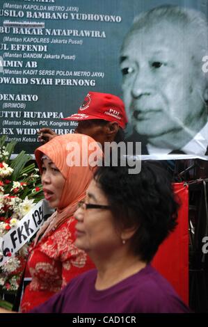 Jul 26, 2010 - Jakarta, Indonesia - Survivors of the 1996 tragedy and members of PDIP, President Megawati Sukarnoputri's political party offer flowers infornt of Suharto Potrait banner, during a ceremony in front of the ex-PDIP head office in Jakarta. PDIP members were attacked and arrested by unide Stock Photo