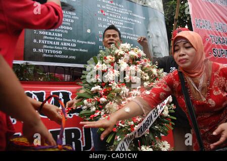 Jul 26, 2010 - Jakarta, Indonesia - Survivors of the 1996 tragedy and members of PDIP, President Megawati Sukarnoputri's political party offer flowers infornt of Suharto Potrait banner, during a ceremony in front of the ex-PDIP head office in Jakarta. PDIP members were attacked and arrested by unide Stock Photo