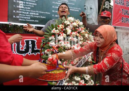 Jul 26, 2010 - Jakarta, Indonesia - Survivors of the 1996 tragedy and members of PDIP, President Megawati Sukarnoputri's political party offer flowers infornt of Suharto Potrait banner, during a ceremony in front of the ex-PDIP head office in Jakarta. PDIP members were attacked and arrested by unide Stock Photo