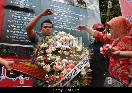 Jul 26, 2010 - Jakarta, Indonesia - Survivors of the 1996 tragedy and members of PDIP, President Megawati Sukarnoputri's political party offer flowers infornt of Suharto Potrait banner, during a ceremony in front of the ex-PDIP head office in Jakarta. PDIP members were attacked and arrested by unide Stock Photo