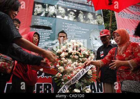 Jul 26, 2010 - Jakarta, Indonesia - Survivors of the 1996 tragedy and members of PDIP, President Megawati Sukarnoputri's political party offer flowers infornt of Suharto Potrait banner, during a ceremony in front of the ex-PDIP head office in Jakarta. PDIP members were attacked and arrested by unide Stock Photo