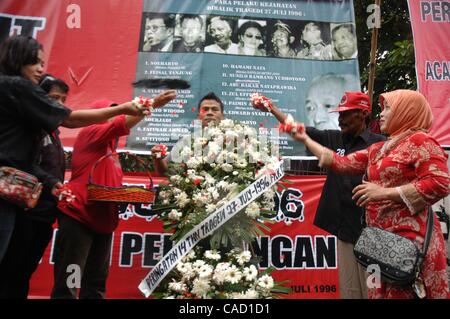 Jul 26, 2010 - Jakarta, Indonesia - Survivors of the 1996 tragedy and members of PDIP, President Megawati Sukarnoputri's political party offer flowers infornt of Suharto Potrait banner, during a ceremony in front of the ex-PDIP head office in Jakarta. PDIP members were attacked and arrested by unide Stock Photo