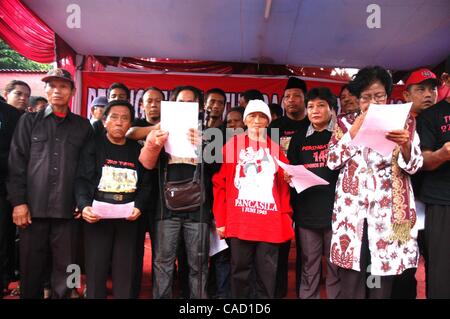 Jul 26, 2010 - Jakarta, Indonesia - Survivors of the 1996 tragedy and members of PDIP, President Megawati Sukarnoputri's political party offer flowers infornt of Suharto Potrait banner, during a ceremony in front of the ex-PDIP head office in Jakarta. PDIP members were attacked and arrested by unide Stock Photo