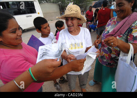 Aug 12, 2010 - Reynosa, Mexico - As she checks the line of residents that have gathered in the Colonia of Satelite Uno, DIANNE HURMAN is surrounded by smiling mothers giving her copies of birth certificates of their children, so that those children will recieve birthday cakes at the end of the day f Stock Photo