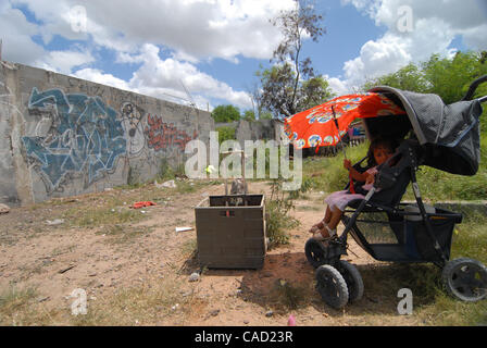 Aug 12, 2010 - Reynosa, Mexico - Waiting in an alley that minutes before had been filled with residents, a young child waits for her father who is in the food line at the Frank Ferree distribution point in the colonia of Satelite Uno. (Credit Image: © Josh Bachman/ZUMApress.com) Stock Photo