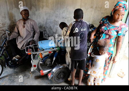 Aug. 5, 2010 - Kano, KANO, NIGERIA - Kabiru Nuhu, 50, has suffered from polio for many years. He and his  wife and children have survived with aid from the Kano State Polio Victims Trust Association. He sits on his donated hand cranked wheelchair next to his modified motorcycle that he only rides wh Stock Photo