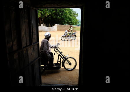 Aug. 5, 2010 - Kano, KANO, NIGERIA - Kabiru Nuhu, 50, has suffered from polio for many years. He and his  wife and children have survived with aid from the Kano State Polio Victims Trust Association. He rides on his donated hand cranked wheelchair outside the door of his home in Kano, Nigeria. .Reli Stock Photo