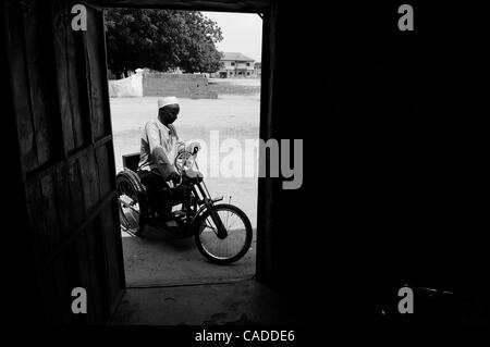 Aug. 5, 2010 - Kano, KANO, NIGERIA - KABIRU NUHU, 50, rides on his donated hand cranked wheelchair outside the door of his home. Nuhu has suffered from polio for many years. He and his  wife and children have survived with aid from the Kano State Polio Victims Trust Association. (Credit Image: © Mar Stock Photo