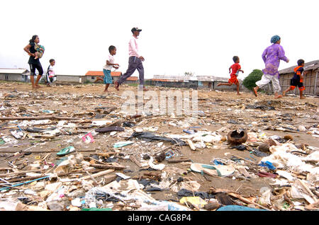 Resident passes a beach covered in flotsam and jetsam that previously was partly mangrove forest, in Jakarta bay on February 16, 2008.. There is less than 150 hectares of mangrove remaining around Jakarta, after authorities in Jakarta launched reclamation programs in the 1980s for development progra Stock Photo