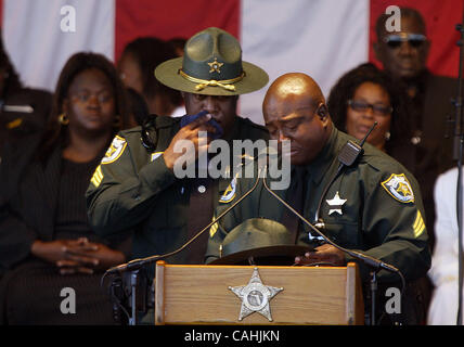 120507 pbso tj 6 -- Palm Beach Post staff photo by Taylor Jones/0045802D. FOR TEAM COVERAGE. SUBURBAN WEST PALM BEACH. Palm Beach County Sheriff's Office Sgt. Dererk Savage(cq), right, grabs his hat as he leaves the podium after speaking about his friend, fallen deputy Donta Manuel. At left is PBSO  Stock Photo