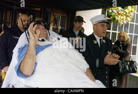 Firefighter Brian Smith, 43, of Ladder Company 44, waves as he is released from New York-Presbyterian Weill Cornell Medical Center on East 68th Street. Smith fell 30 feet from a ladder bucket while fighting a fire in the Bronx 22 days ago and suffers from a broken C1 vertebra, a cracked pelvis, punc Stock Photo