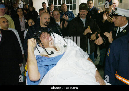 Firefighter Brian Smith, 43, of Ladder Company 44, pumps his fist as he is released from New York-Presbyterian Weill Cornell Medical Center on East 68th Street. Smith fell 30 feet from a ladder bucket while fighting a fire in the Bronx 22 days ago and suffers from a broken C1 vertebra, a cracked pel Stock Photo