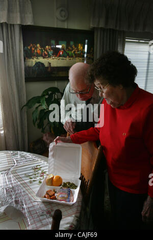 OPTIONAL JUMP Inside their trailer home with a picture of the last supper on the wall. Arthur and Effie Jordan open up the box lunch delivered by firefighter Rick Vasquez and his family. Each year, Sacramento city and metro fire fighters fill in for Meals on Wheels volunteers on Christmas Day, handi Stock Photo