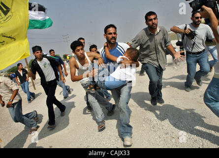 Oct 01, 2007 - Gaza City, Palestinian Territories - A Palestinian man rushes with a wounded boy after he was shot while waiting for released relatives from Israeli prisons, at the Erez crossing, northern Gaza Strip. Two people, including the child, were wounded when Israeli troops opened fire toward Stock Photo