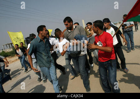 Oct 01, 2007 - Gaza City, Palestinian Territories - A Palestinian man rushes with a wounded boy after he was shot while waiting for released relatives from Israeli prisons, at the Erez crossing, northern Gaza Strip. Two people, including the child, were wounded when Israeli troops opened fire toward Stock Photo