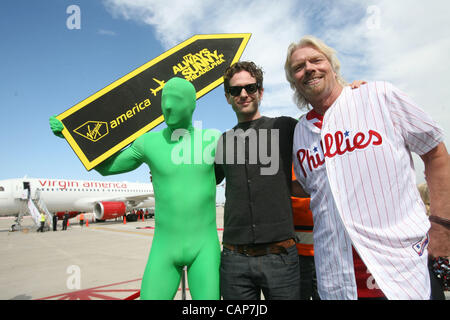 April 4, 2012 - Philadelphia, California, U.S. - Sir Richard Branson (R), actor Glenn Howerton (center) and the Green Man from the TV show ''It's Always Sunny In Philadelphia'' are photographed during a ceremony for the Launch of Virgin America's First Flight from Los Angeles to Philadelphia on Wedn Stock Photo