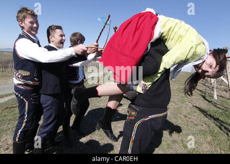 Boys in folk customs carry a giant 'pomlazka' (plated willow stems) to whip girls during traditional celebration of Easter Monday in Nemcicky, South Moravia, on Monday, April 9, 2012. The tradition of whipping girls and women with plaited willow stems and splashing them with cold water should assure Stock Photo