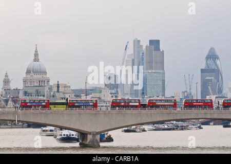LONDON, UK, 12th  April 2012.  Red, double-decker buses form an unusual, stationary queue on Waterloo Bridge as police prevent access to nearby Victoria Embankment.  Due to a traffic accident all immediate, local roads were at a standstill in the middle of the evening rush hour. Stock Photo