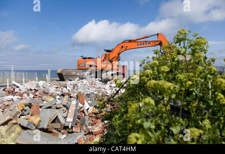 Happisburgh,Norfolk, UK. Tuesday 17th April 2012. Diggers start the demolition of the RNLI Lifeboat station at Beach Road in the village & get ready to demolish the MCA Coastaguard station as they are dangerously close to falling into the sea due to coastal erosion Stock Photo