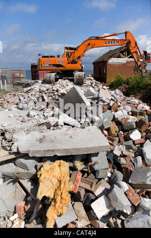 Happisburgh, Norfolk, UK. Tuesday 17th April 2012. Diggers start the demolition of the RNLI Lifeboat station at Beach Road in the village & get ready to demolish the MCA Coastaguard station as they are dangerously close to falling into the sea due to coastal erosion Stock Photo