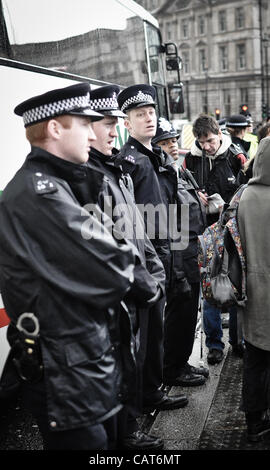 18/04/12, London, UK: Line of police officers stand watch as wheelchair-users block the road at Trafalgar Square. The protest was intended to highlight issues faced by disabled people and changes to disability benefits. Stock Photo