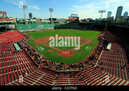 Boston, Massachusetts, USA. April 19, 2012. Forty Five minutes after Fenway Park opened to the public for an open house on its 100th Anniversary. Thousands of Red Sox fans encircle the ballfield in order to catch a glimpse of the dugouts, green monster left field wall and the bullpens.