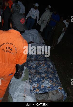 Islamabad, Pakistan, April 20, 2012: Rescue workers collecting bodies of passengers killed in the plane crash near Islamabad, the capital of Pakistan. Stock Photo