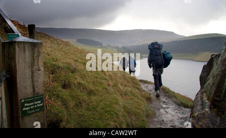 Peak District National Park, Derbyshire, UK. Ramblers on the Kinder Scout mass trespass route against Kinder plateau and Kinder reservoir. The protest gave the area a place in the history of the campaign for National Parks. Stock Photo