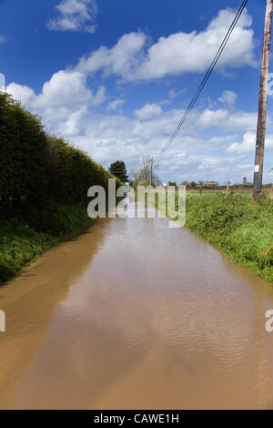 Heavy rain causes flooding in North Norfolk, UK on Thursday 26th April 2012. Pictured are the muddy flood waters of a country lane. Stock Photo