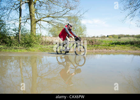 30th April 2012. Billericay, Essex, UK. A cyclist makes his way through the flooded road at a regular flood spot known as Buttsbury Wash. Stock Photo