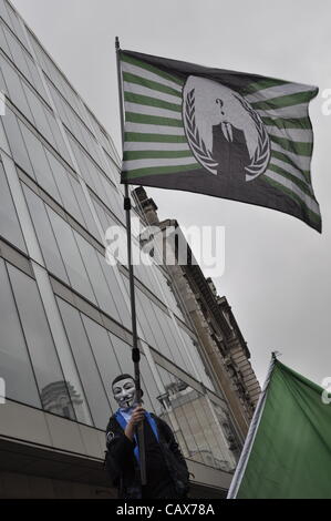 01 May 2012 London UK. A member of the 'Anonymous' movement waves a flag during London's annual Trade Union May Day parade. The March followed a route through central London finishing with a Rally in Trafalgar Square Stock Photo
