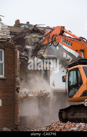 Happisburgh,Norfolk, UK. Tuesday 1st May 2012. Diggers demolish the famous terrace row of houses at Beach Road, Happisburgh in Norfolk as they are dangerously close to falling into the sea due to the effects of coastal erosion. Stock Photo