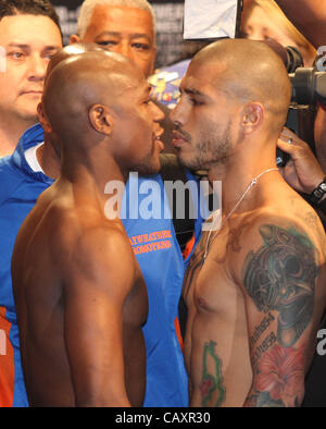 (L to R) Miguel Cotto and Floyd Mayweather face off at the MGM Grand Garden Arena in Las Vegas on May 4, 2012, one day before Cotto attempts to defend his WBA Super Welterweight title against Mayweather.  The victor will also clinch the vacant WBC Diamond Super Welterweight title. Stock Photo