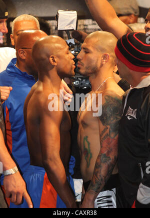 (L to R) Miguel Cotto and Floyd Mayweather face off at the MGM Grand Garden Arena in Las Vegas on May 4, 2012, one day before Cotto attempts to defend his WBA Super Welterweight title against Mayweather.  The victor will also clinch the vacant WBC Diamond Super Welterweight title. Stock Photo