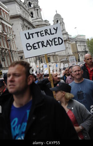 London, UK. 10th May 2012, Man holds a sign reading 'UTTERLY BETRAYED' in support of the Police federation members, off-duty police officers as they march through central London. The Police federation are protesting against the Coalition Government Cuts to public sector pensions. Stock Photo