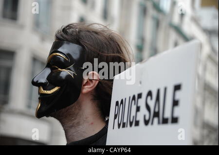 London, UK. 10th May 2012, Masked protester holds 'Police Sale' sign supporting the police federation members and off-duty police officers as they march through central London. Stock Photo